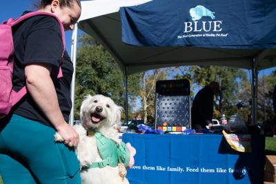 Person and dog in front of the Blue Buffalo booth at Strut Your Mutt