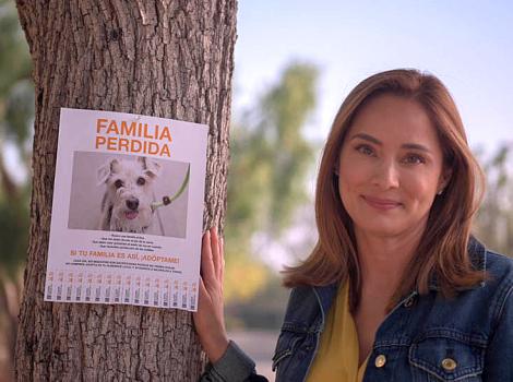 Actress Jacqueline Piñol next to a Lost Family flyer on a tree, written in Spanish