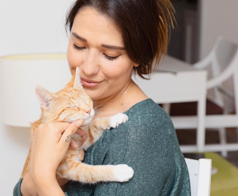 Smiling person holding a tiny kitten