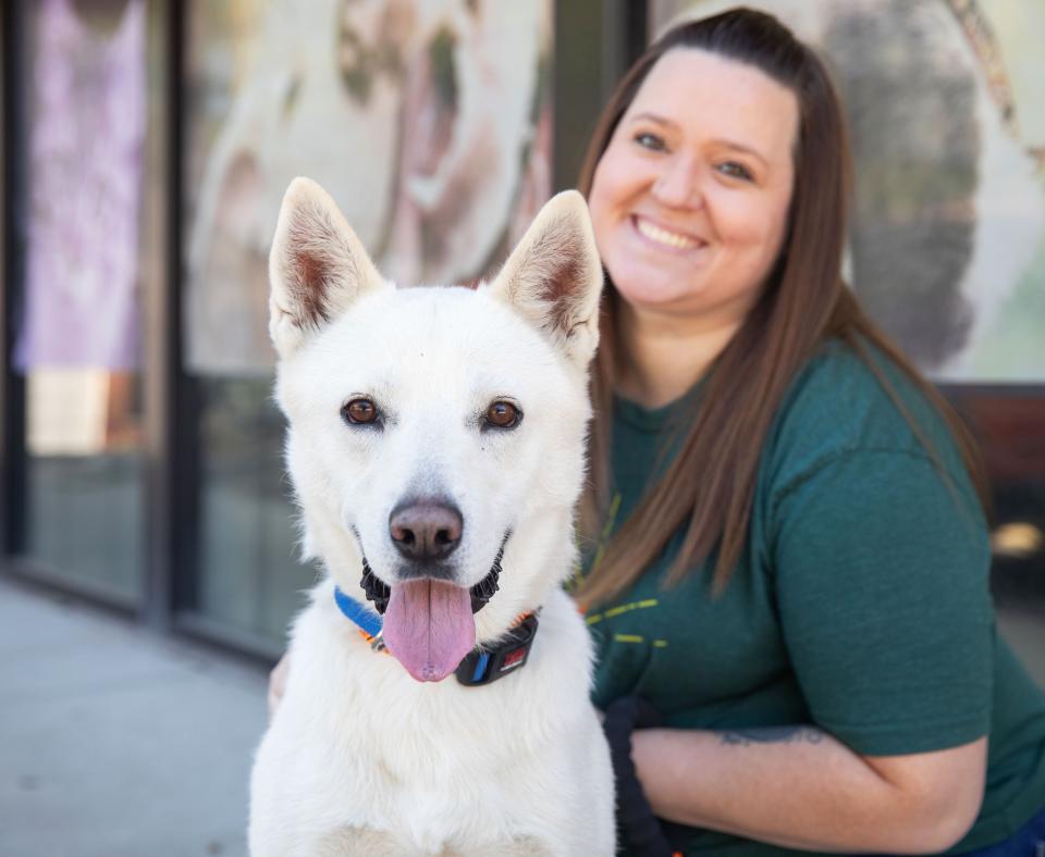 Smiling white dog with a smiling person behind him