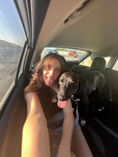 Person with Bert the dog in a vehicle with both of their tongues out