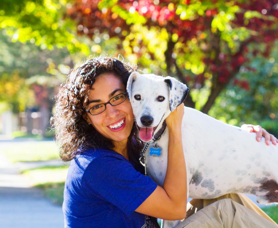 Smiling person hugging a dog outside