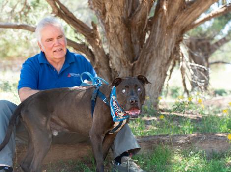 Dan with Moogan the dog outside under a tree