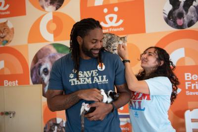 Shamiyan petting a kitten on Abdul's shoulder while he's holding another kitten