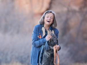 Faith Maloney outside walking two dogs and laughing