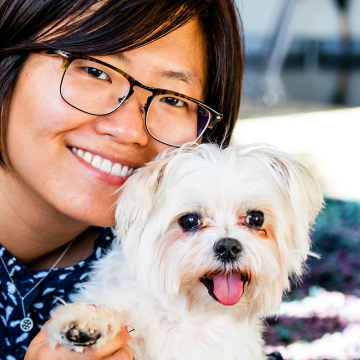 Smiling person with a dog in a bright New York City home