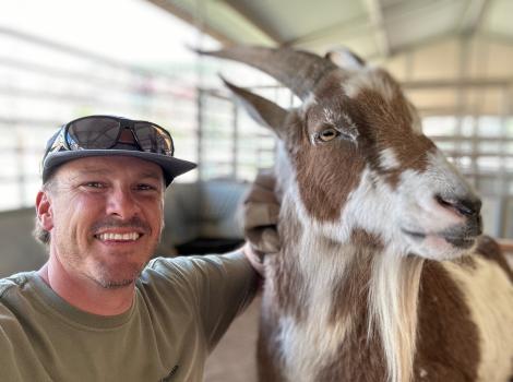 Smiling volunteer from the MenHealing group with a goat