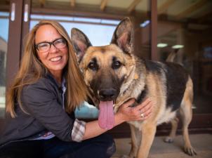 Julie Castle hugging Sunny the German shepherd