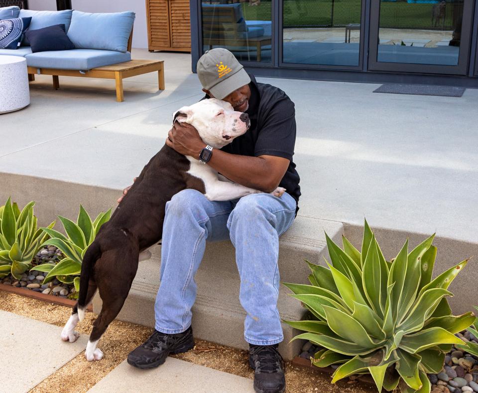 Person holding a dog close while sitting on patio steps