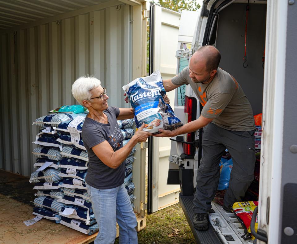 People unloading a bag of pet food from a transport truck