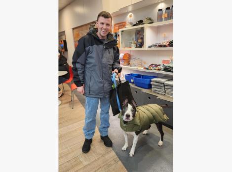 Jack Dugan with Lucky Charm the dog, who is wearing a green jacket