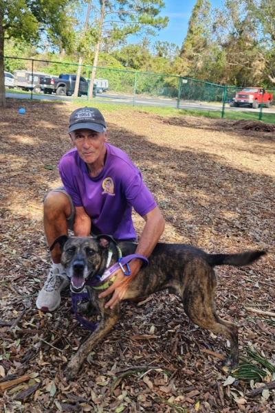 Volunteer Paul White outside with a brindle dog