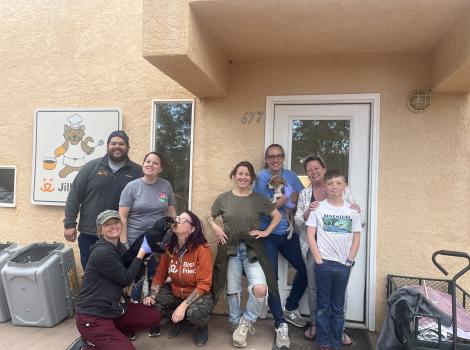 Group of people with some puppies outside one of the buildings in Cat World