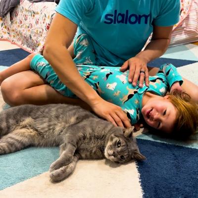 Child lying next to Stone Cold the cat in his new home