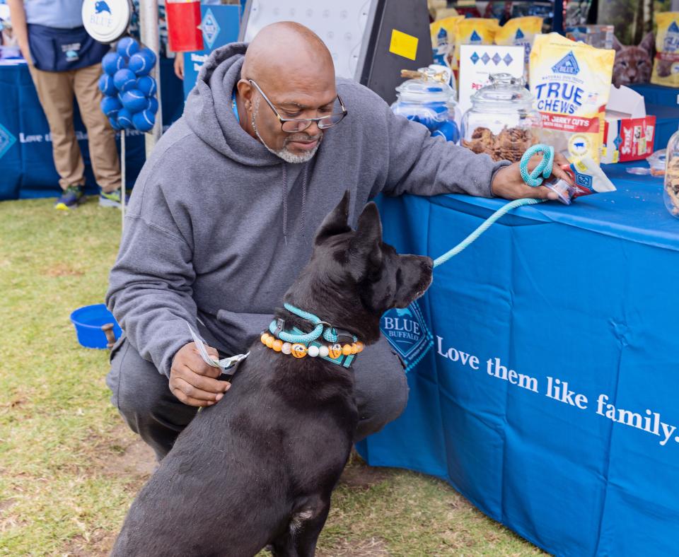 Person and leashed dog at the Blue Buffalo vendor table at the Los Angles Super Adoption