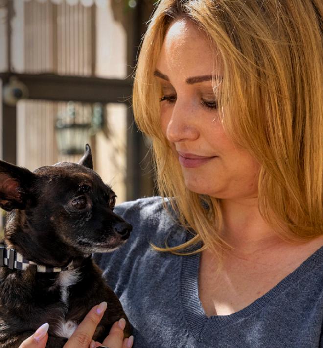 Person holding a tiny dog outside