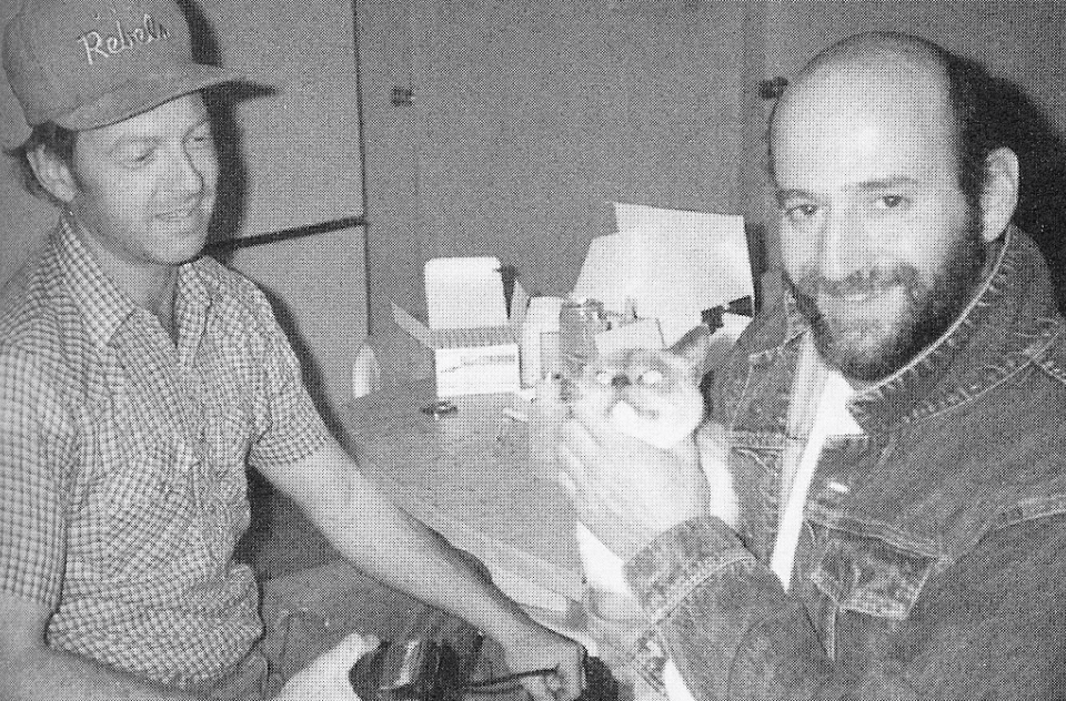 Vintage image of two men, one holding a cat