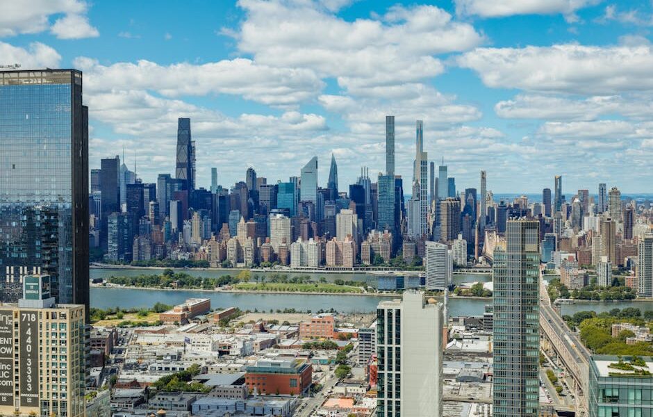 Explore the stunning New York City skyline with a clear view of iconic skyscrapers under a vibrant sky.