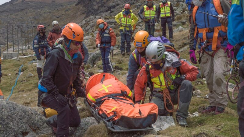 Rescue team performs mountain rescue using a stretcher to aid an injured hiker.