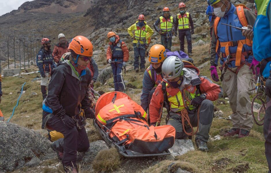 Rescue team performs mountain rescue using a stretcher to aid an injured hiker.