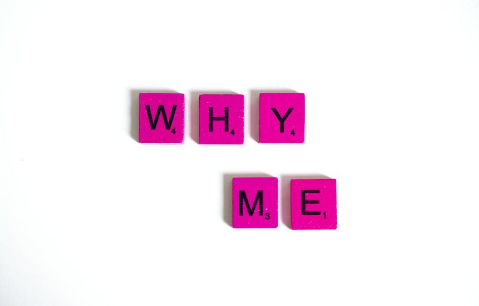 Pink Scrabble tiles form the words 'Why Me' on a white background, emphasizing questioning and introspection.