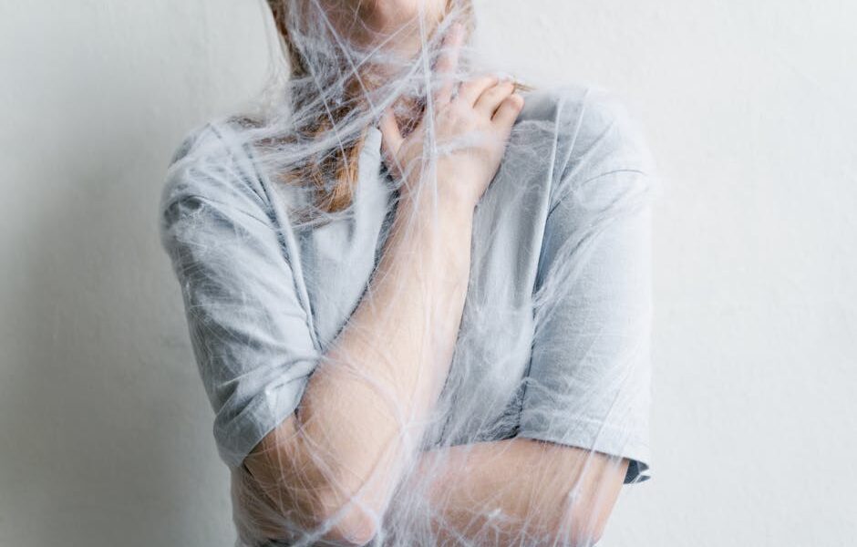 A woman metaphorically trapped in a spider web depicting anxiety and entrapment.