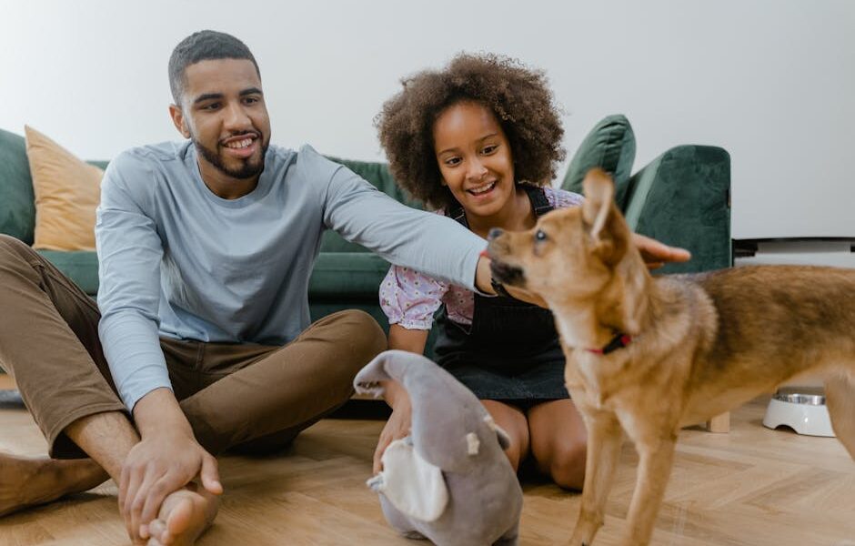 Man and girl enjoying quality time with their dog indoors, promoting family bonding.