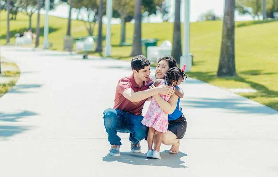 Joyful family hugging in a sunny park, capturing love and happiness.