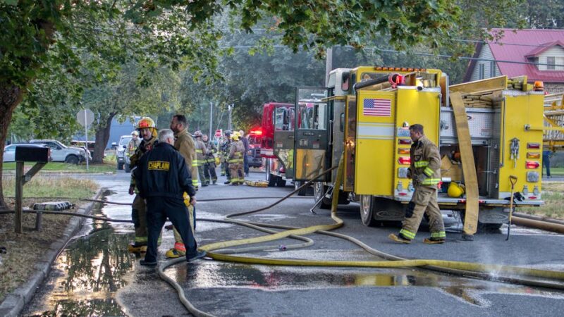 Firefighters working at the scene of an emergency in Chewelah, WA, preparing hoses and equipment.