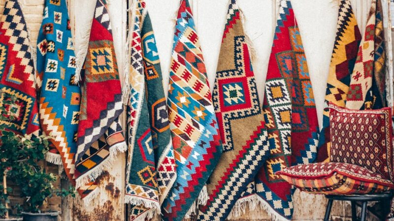 Vibrant Persian rugs hung for display in Shiraz, showcasing traditional Iranian craftsmanship.